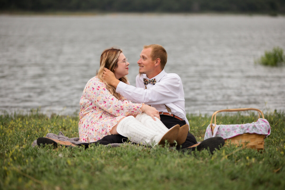 Picnic at the lake with man touching woman's hair