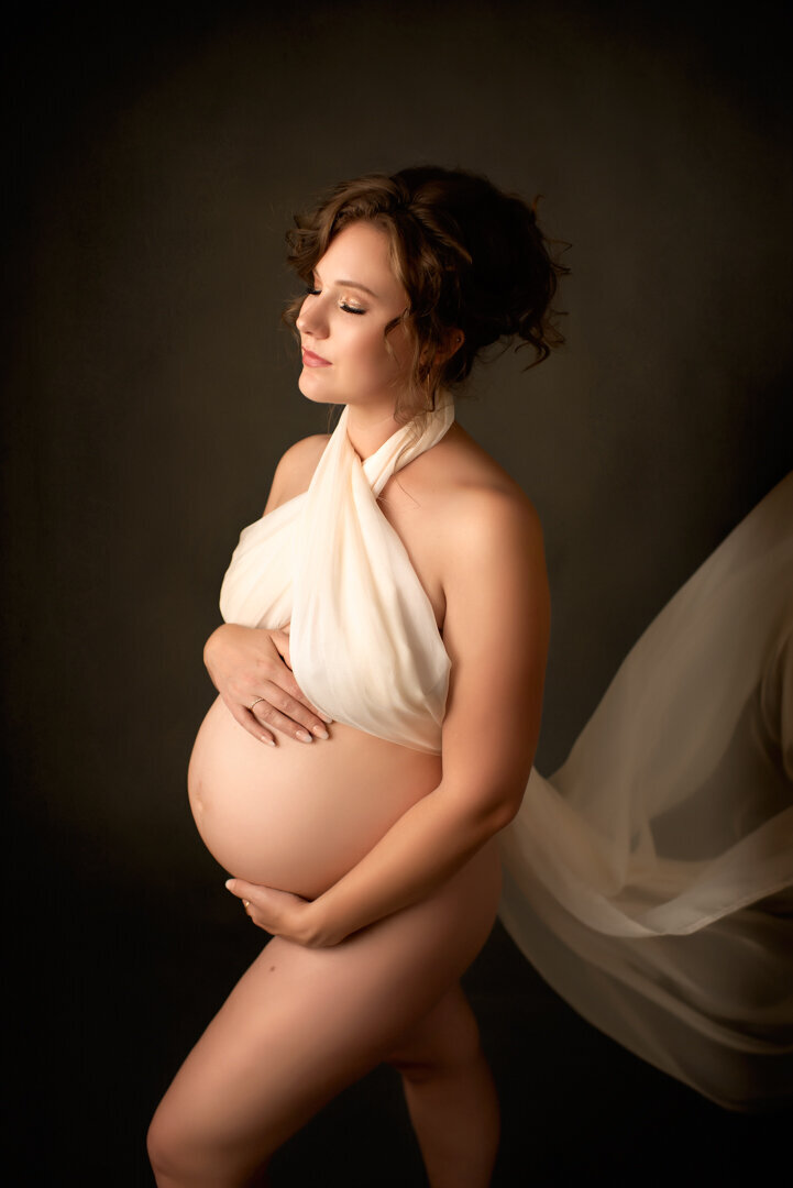 Grand Rapids Maternity Photography Studio Session with White Wrap Holding Belly By For The Love Of Photography