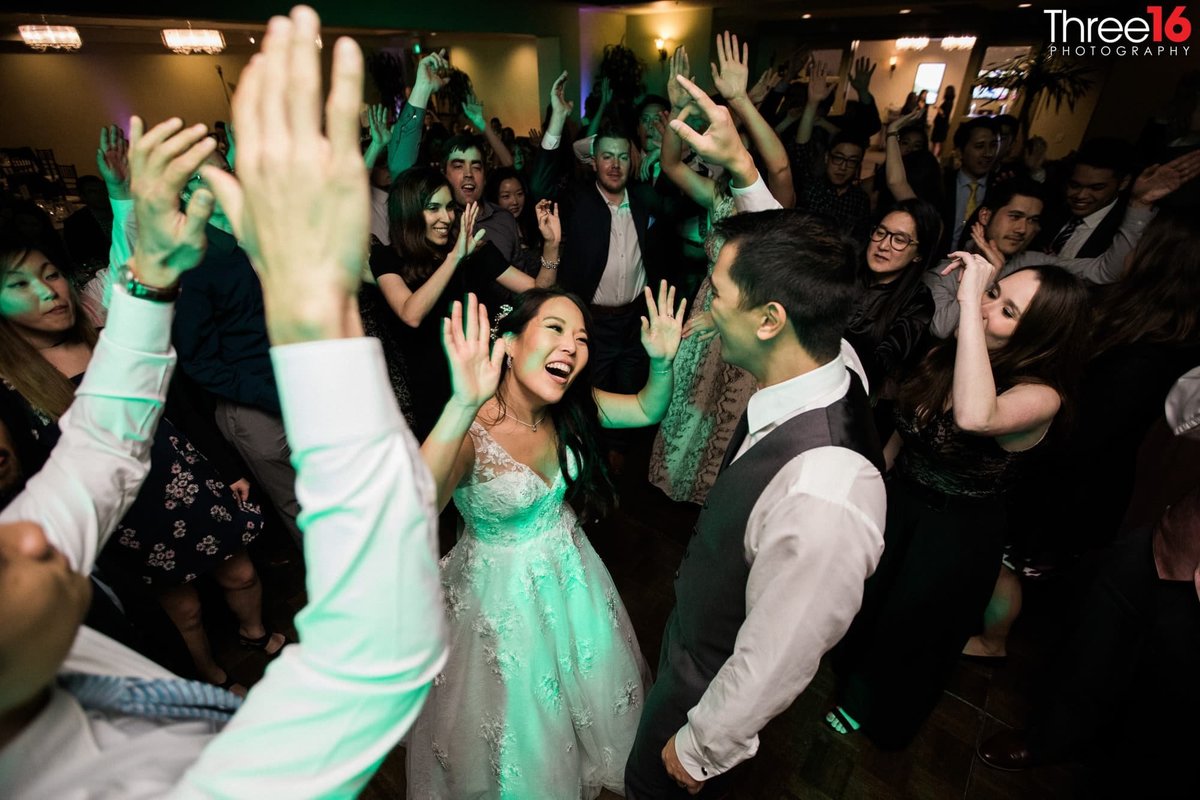 Bride and Groom dance while guest surround them