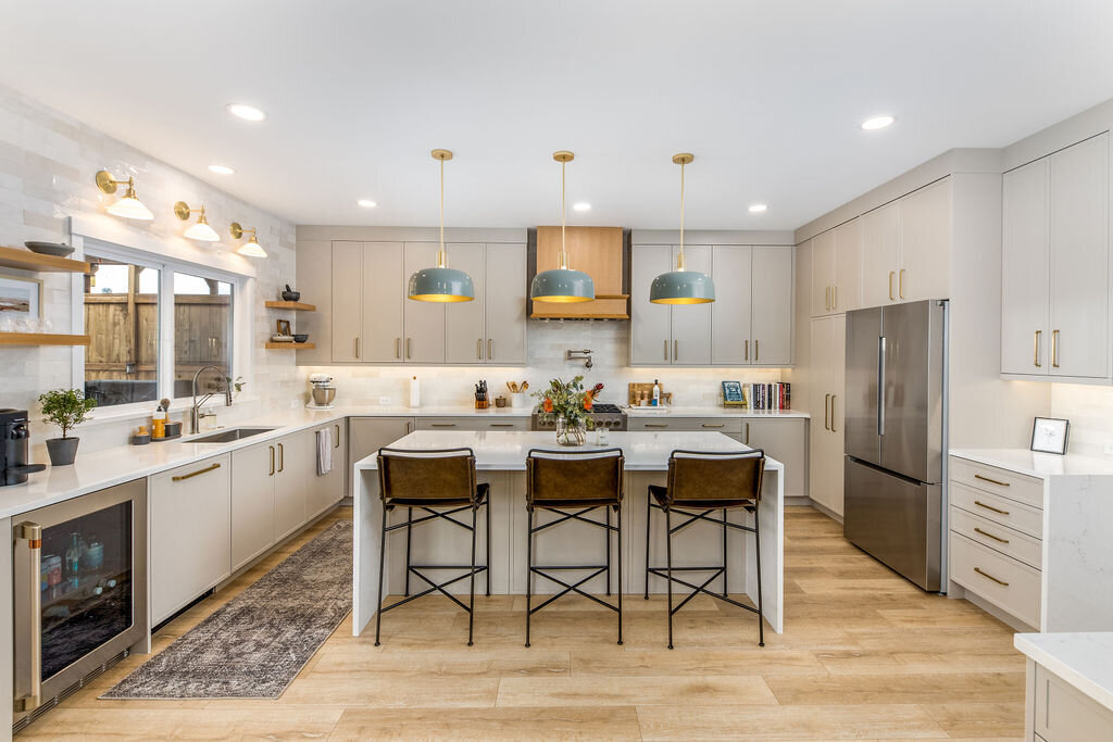 Bright modern kitchen featuring slab cabinetry and light wood floors—designed and supplied by Belle Design Collective in San Diego.