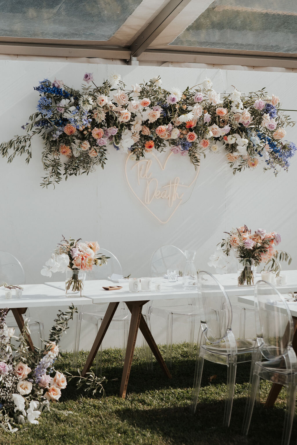 The Vase Floral Co - wedding reception table with floral arrangements and hanging flower design on wall