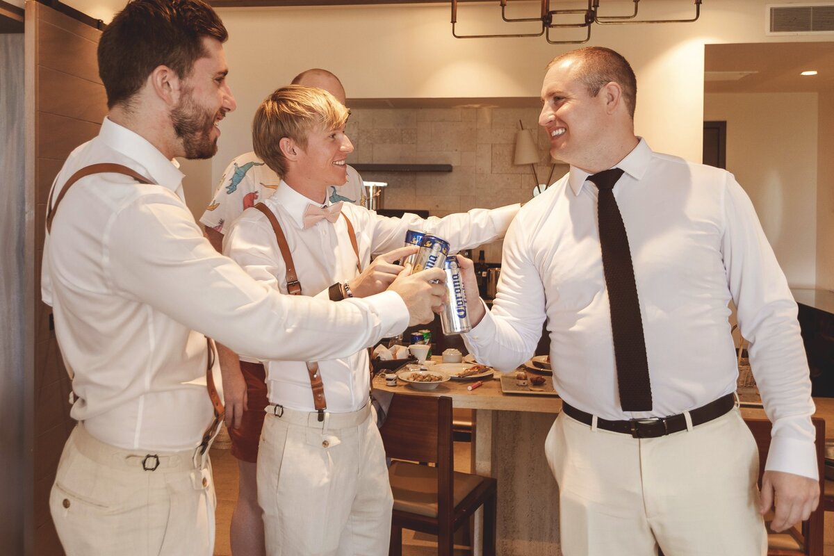 Guys cheersing beers while getting ready at Riviera Maya Wedding