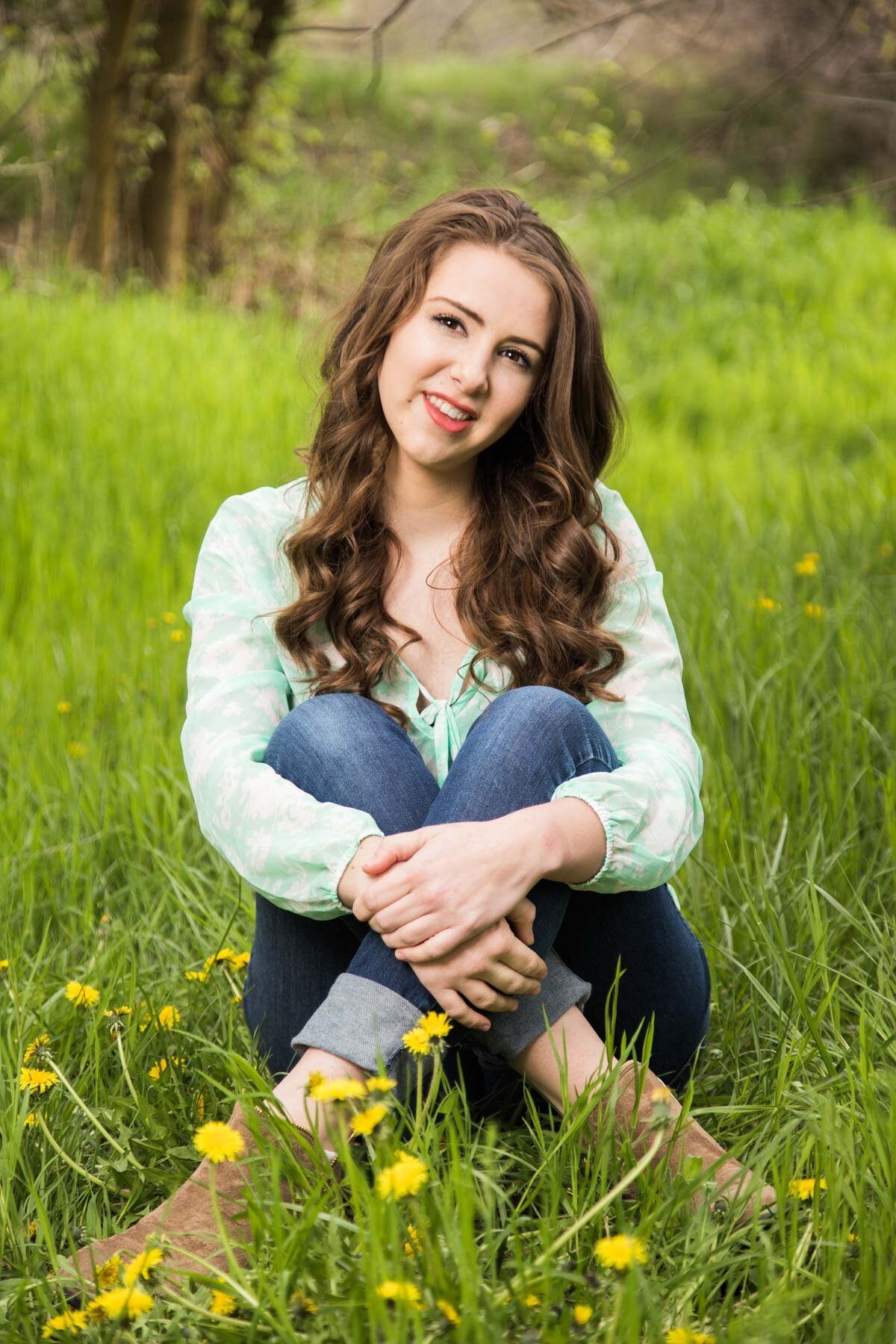 Girl posing for senior pictures in dandelion field at Wheeler Farm in Utah.