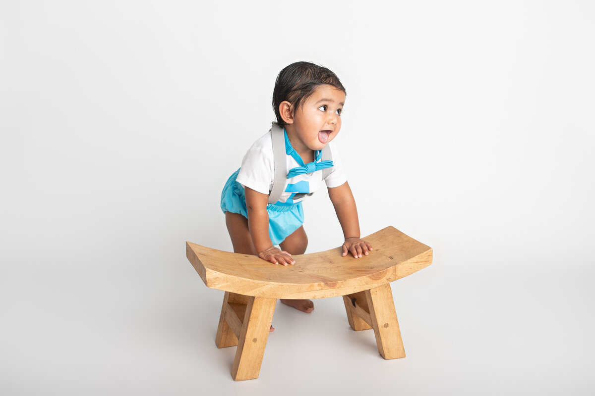 Baby standing near a wooden bench