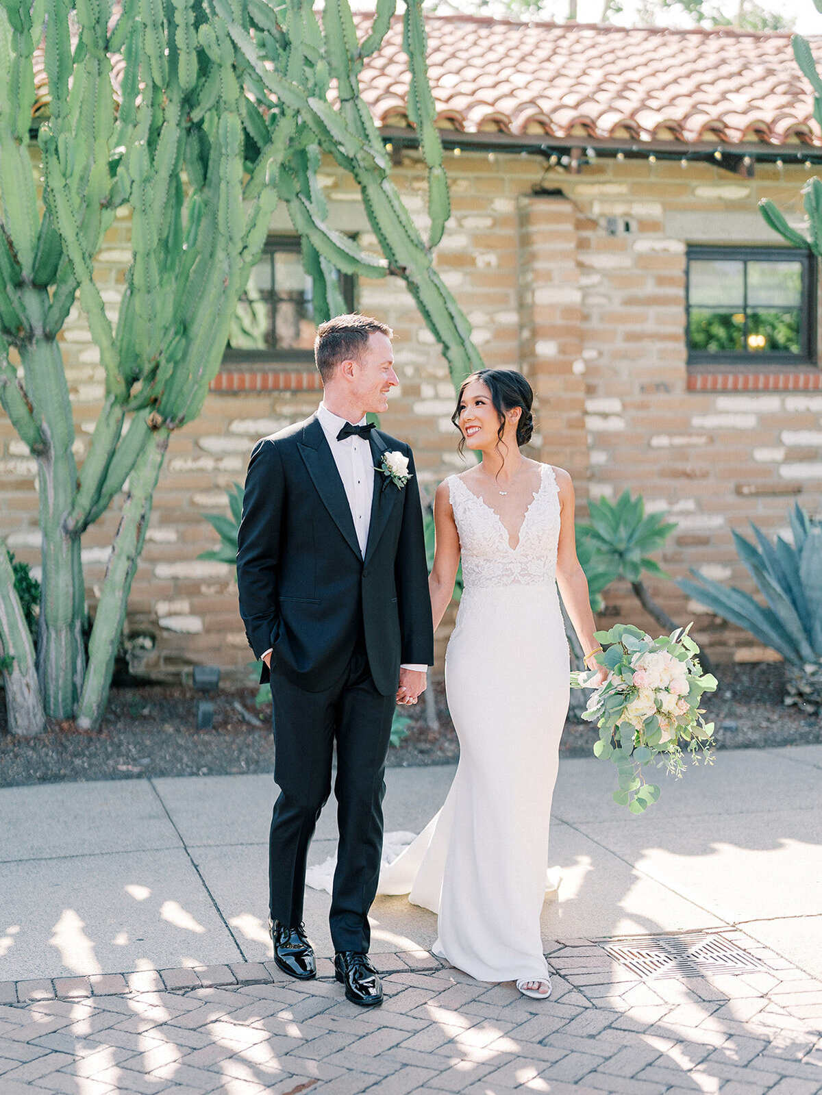 bride and groom walking holding hands in a wedding at estancia in la jolla