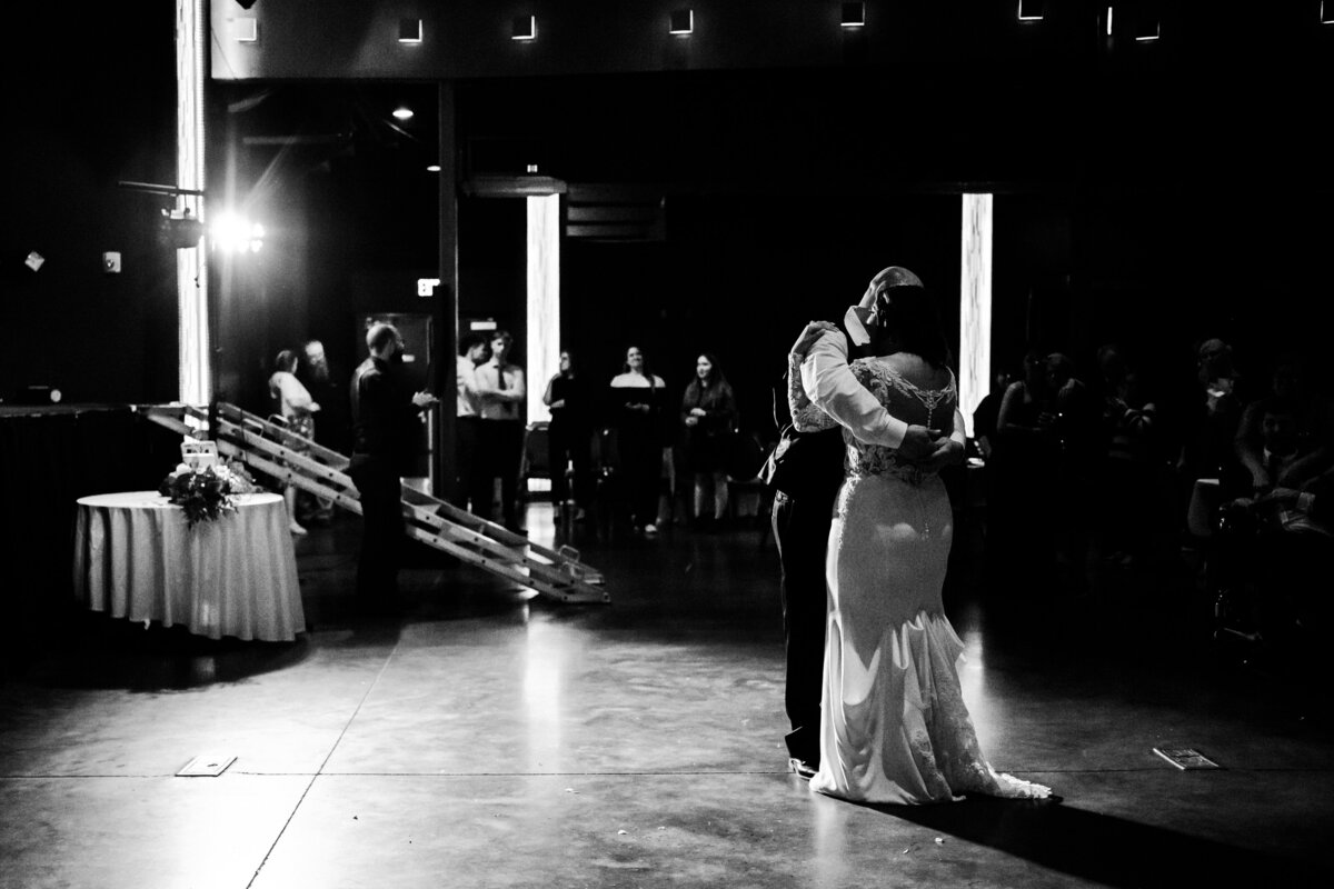 Bride and father share a dance on the dance floor in black and white.