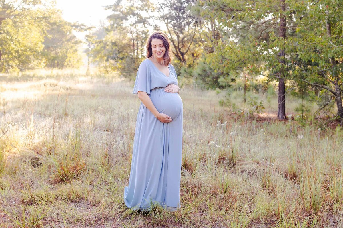 pregnant momma in long blue dress in a field expecting twins in Lexington SC