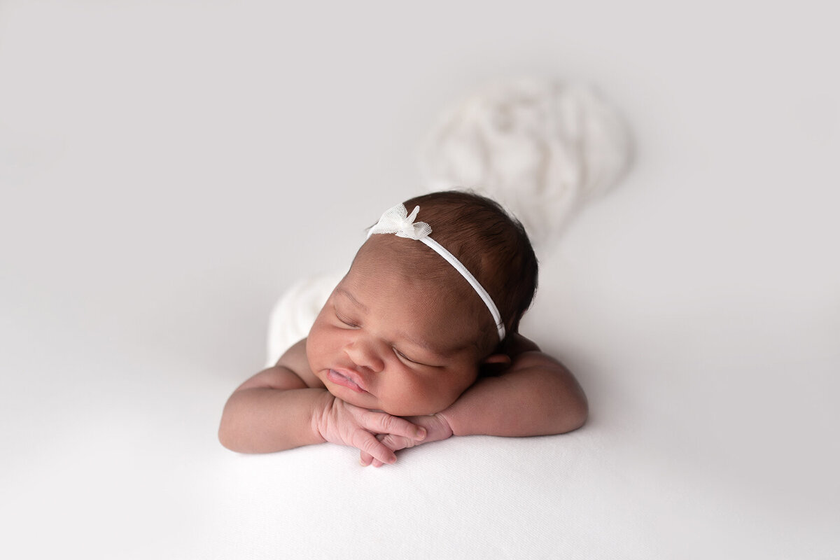 Sleeping newborn with chin on hands photography in Houston by Laura King