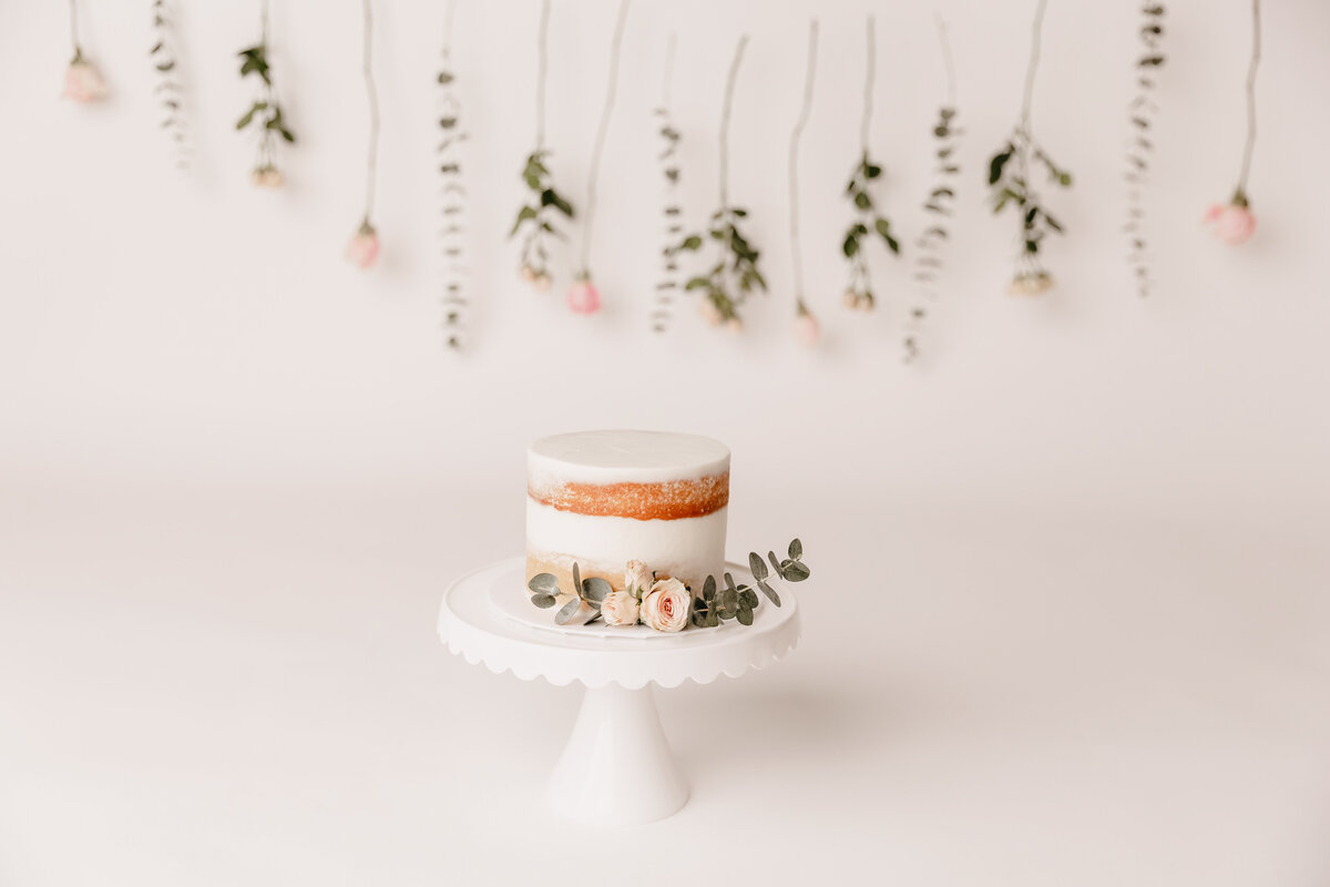 white cake with florals on white backdrop