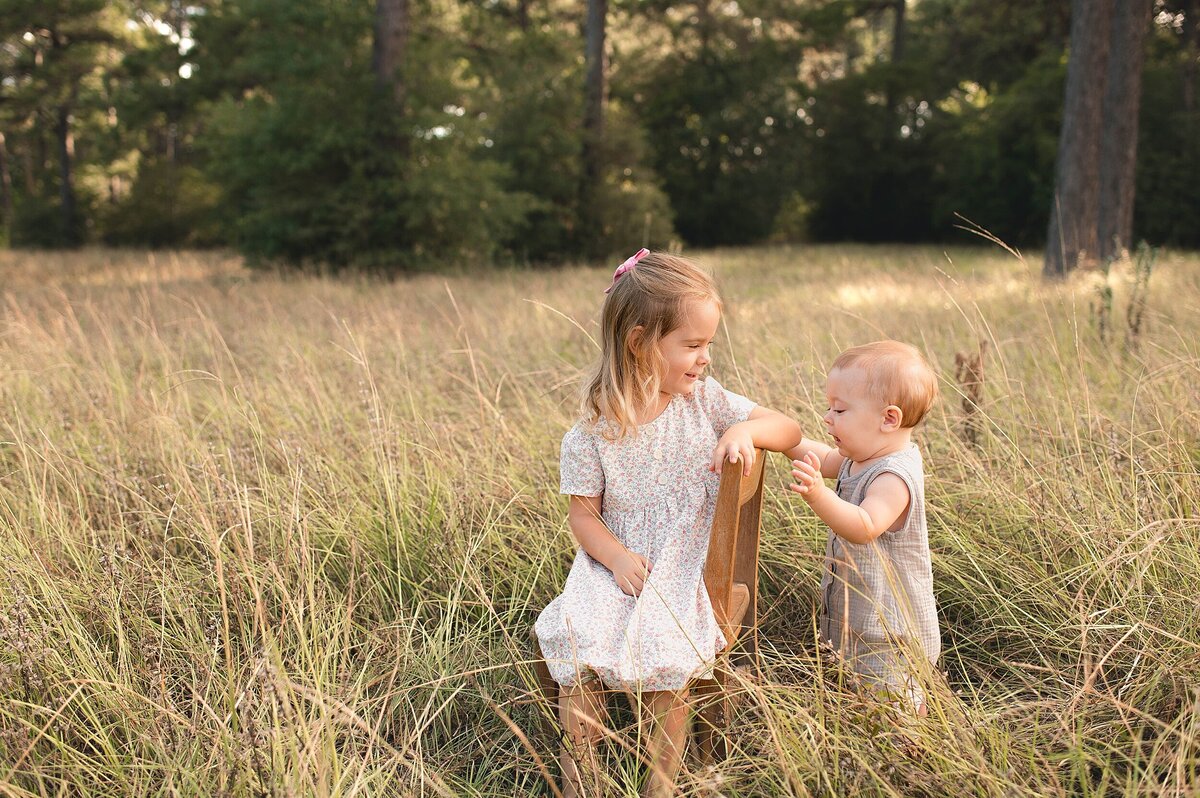 Big sister and little brother in a field by Cypress Texas Photographer