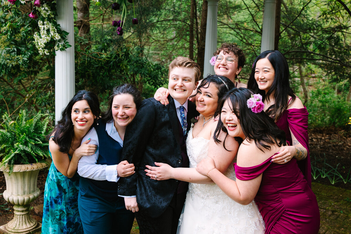 Brides and bridal party hugging