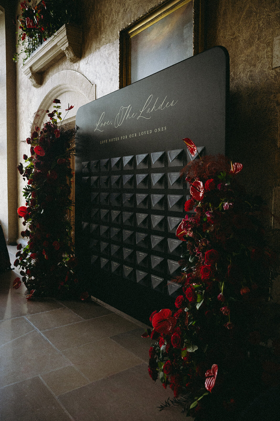 Escort wall with black envelopes and love notes with guest table number and seating assignment