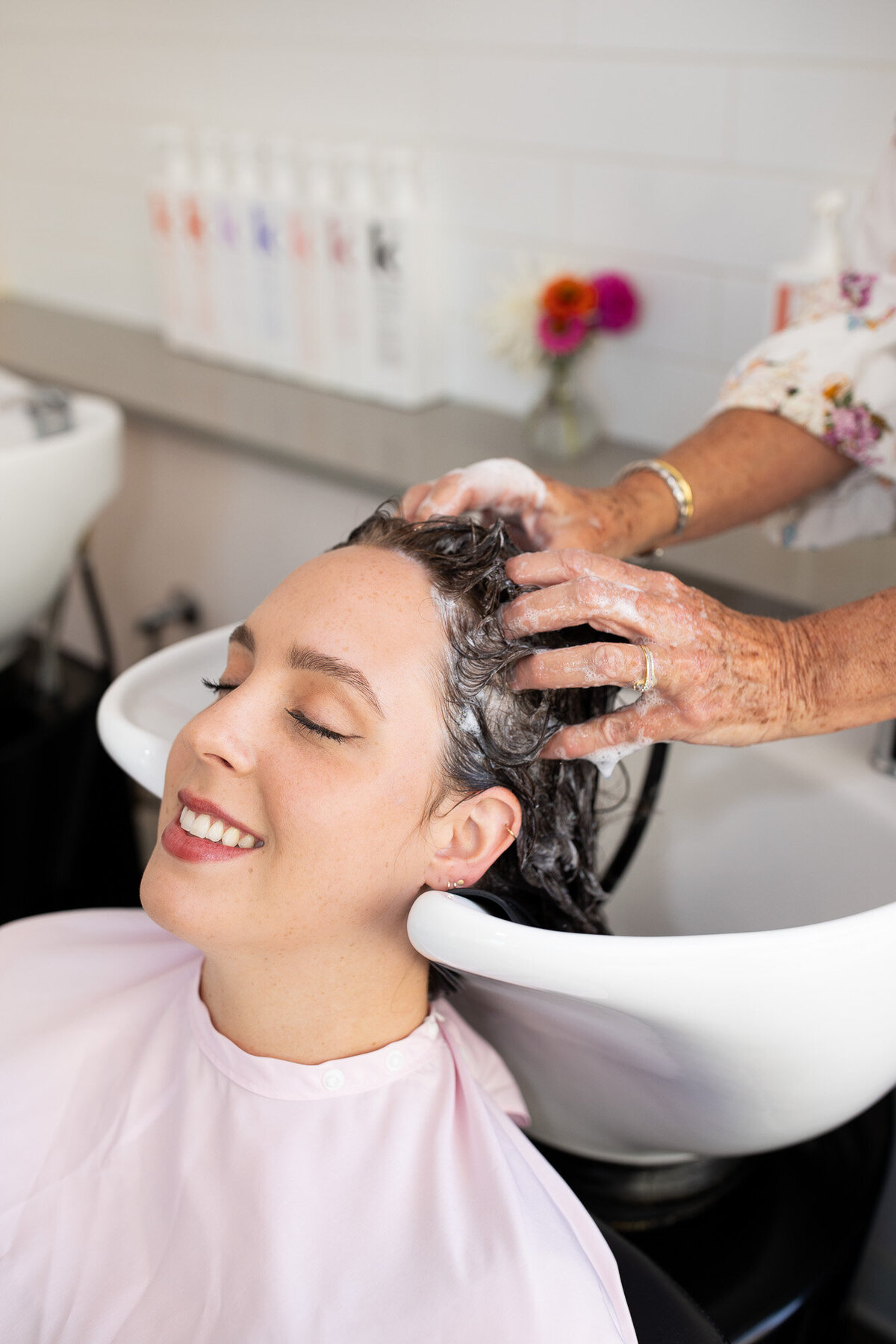 Female gets hair washed in bowl at salon. 