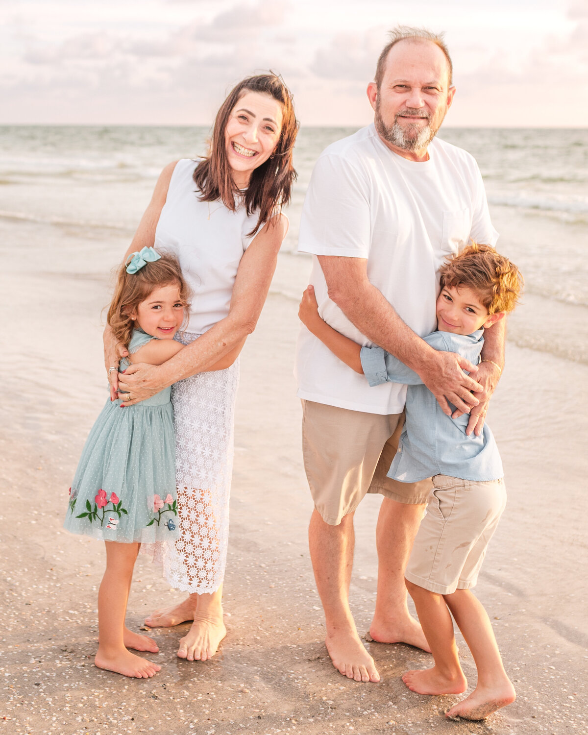Multi-generation family posing together at Indian Rocks Beach with pastel skies.