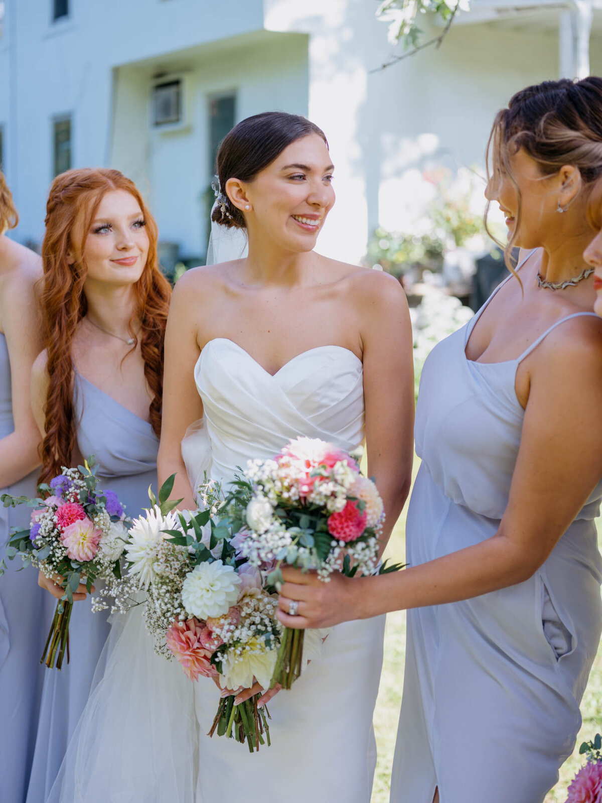 Bride in Maggie Sottero gown with bridesmaids in blue Birdy Grey dresses.