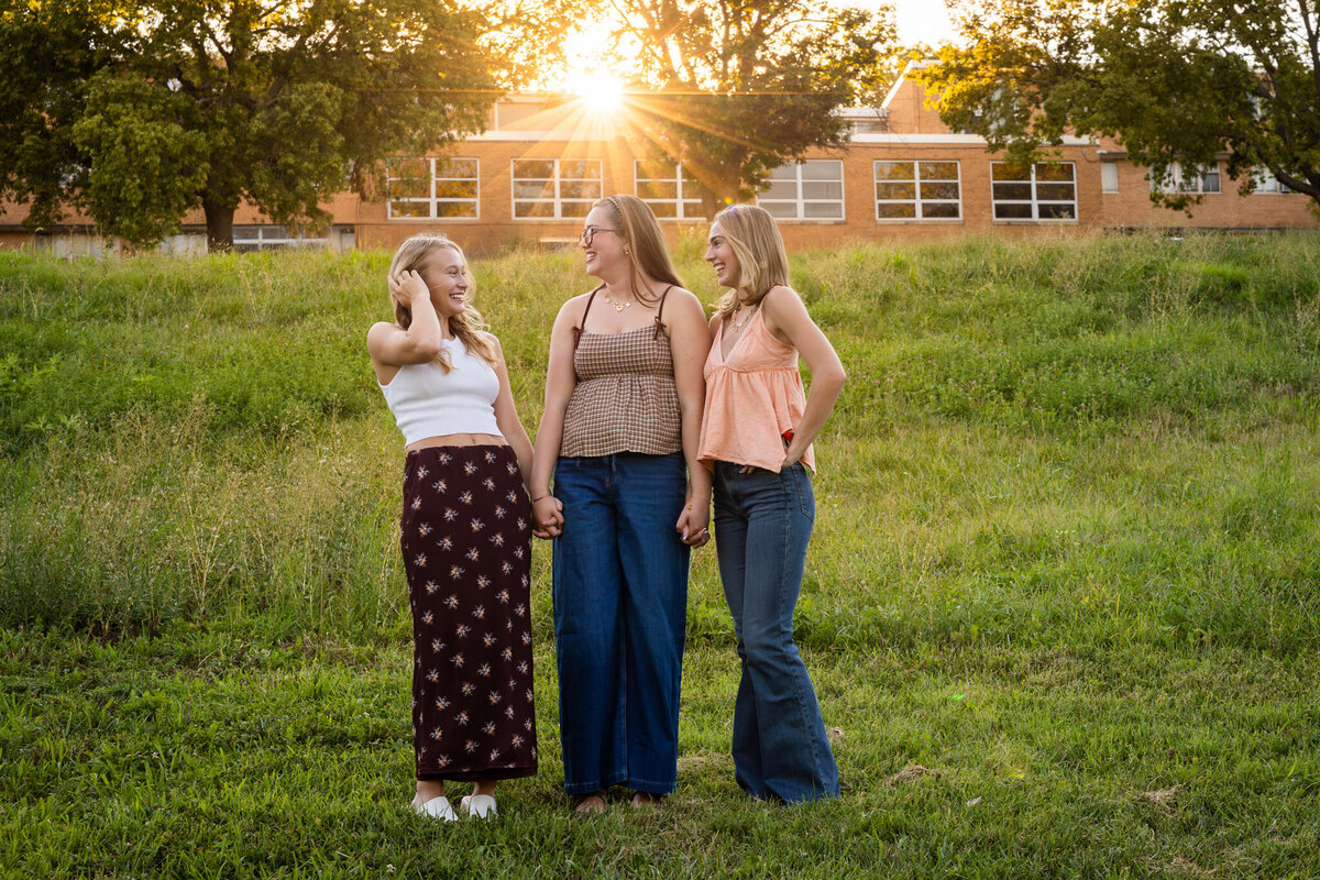 MBP Senior Team standing in a grass field looking and laughing with each other in Lawrence, KS
