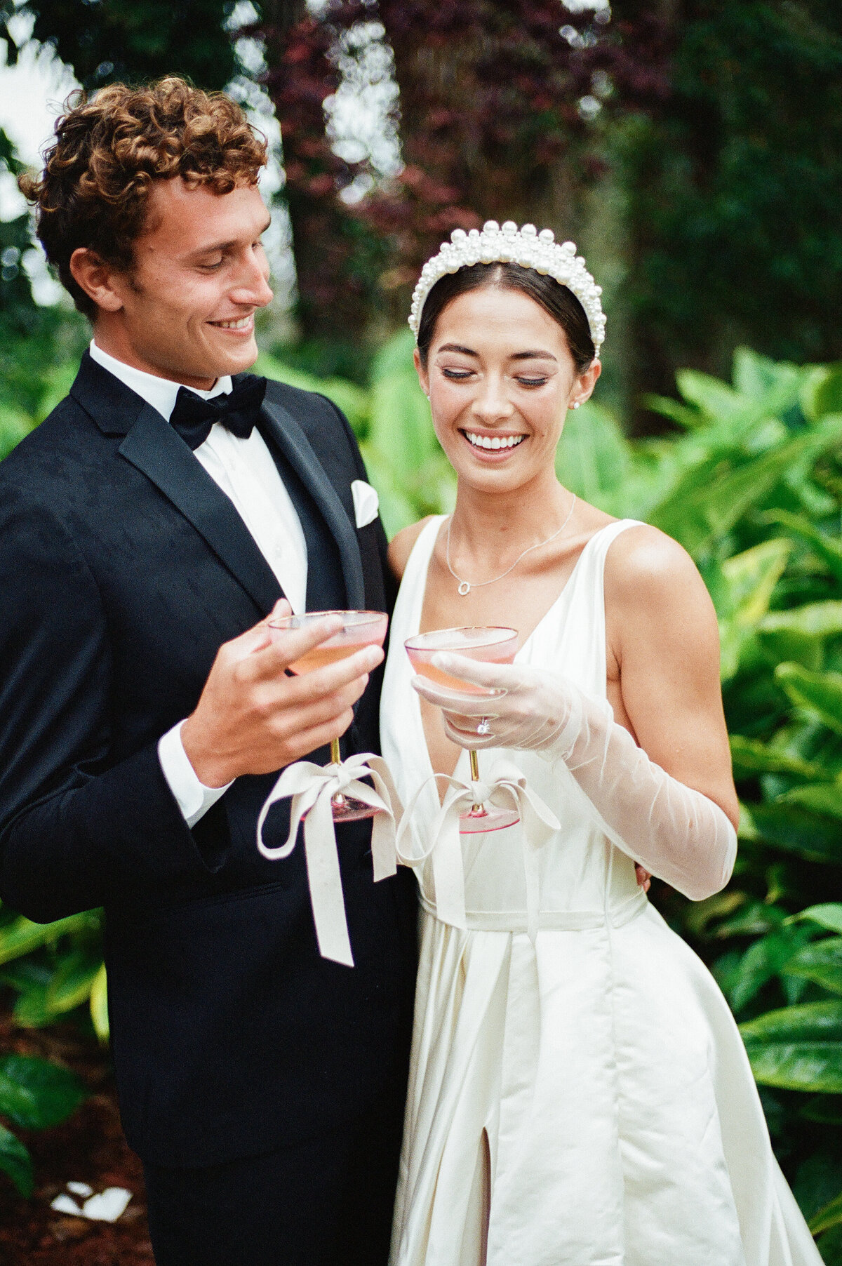 Bride and groom share a champagne toast during their luxury wedding in Hawaii, captured on film by Kate Winters Photography. 