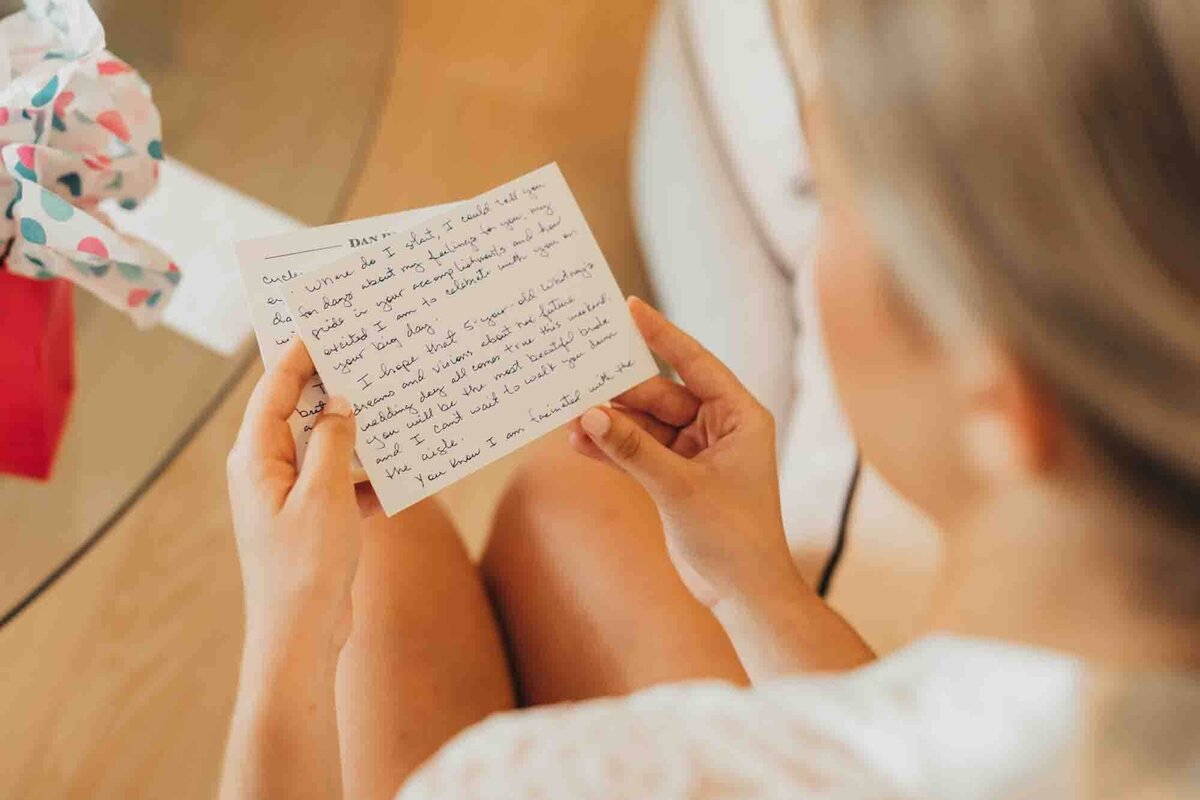 bride reads hand written note from soon to be husband, right before the wedding.