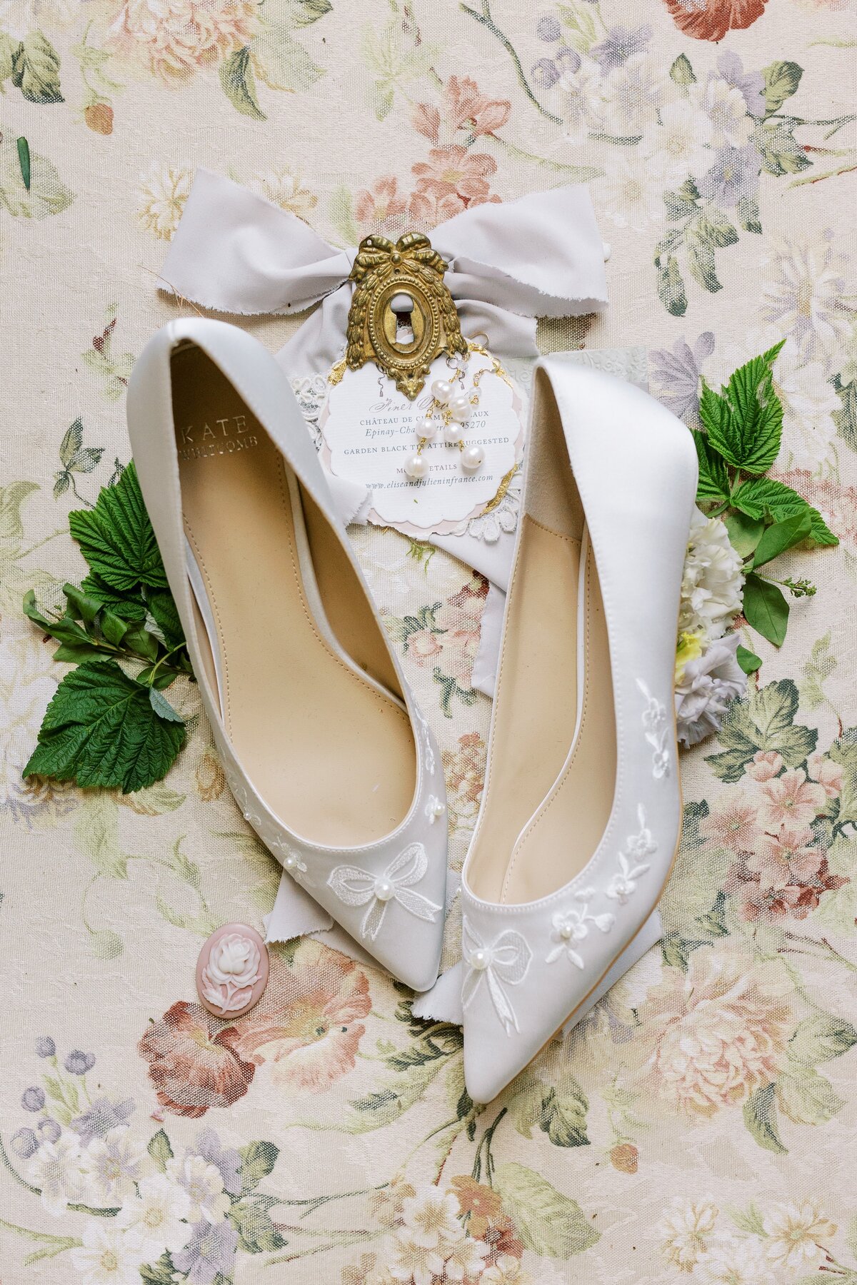 white bridal shoes with flowers around them