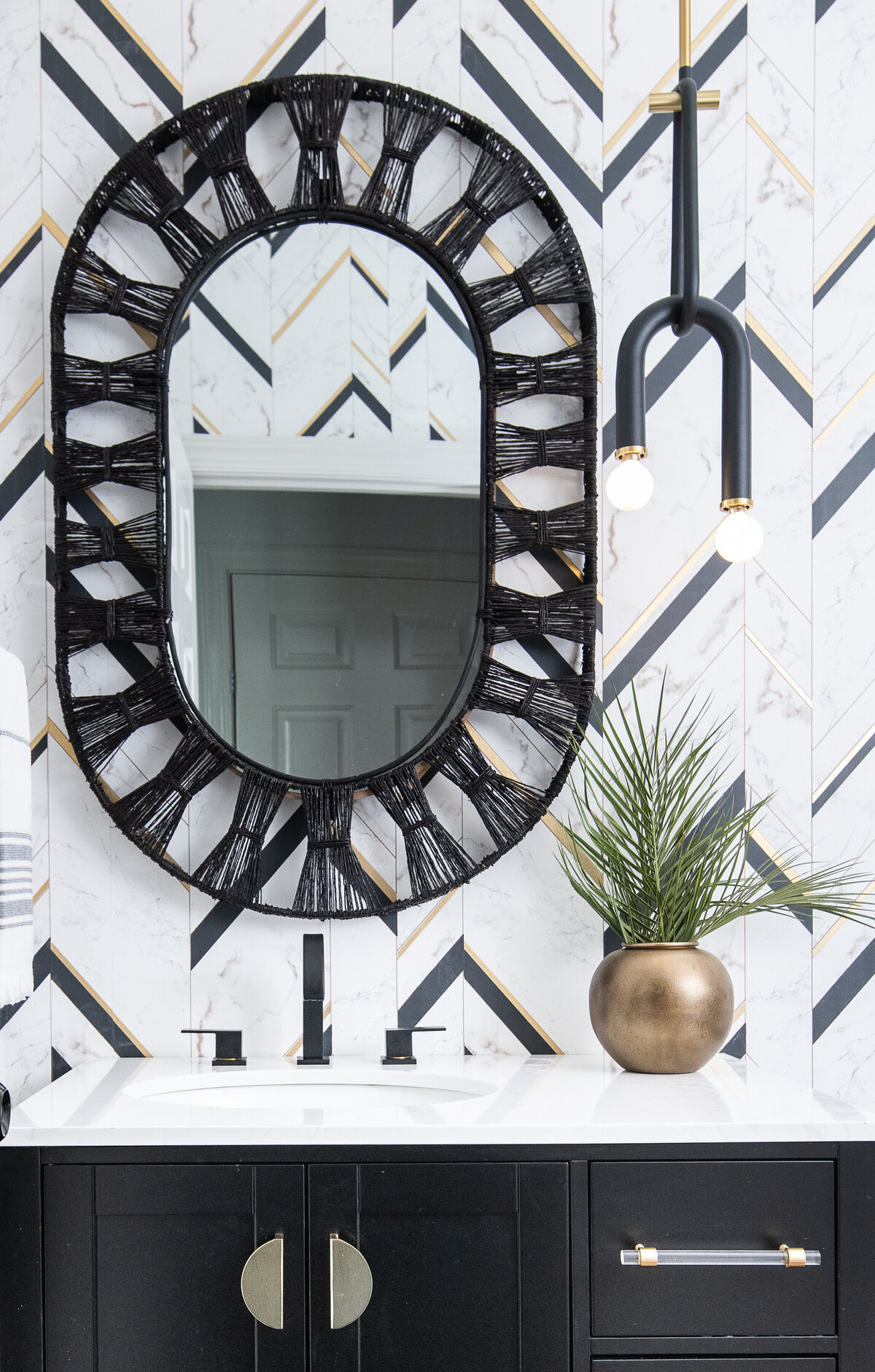 a mirror with a black, abstract frame design hanging over a bathroom sink