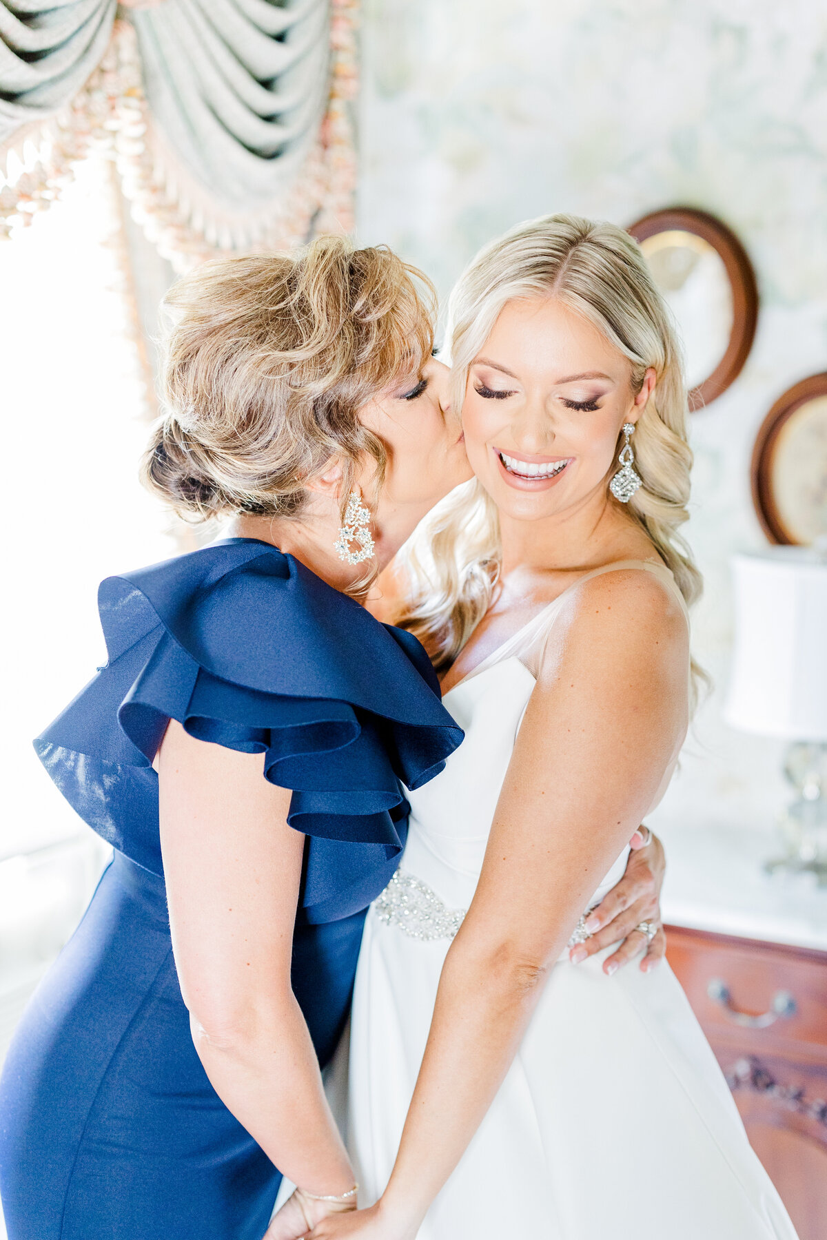 bride with mother while getting ready for wedding