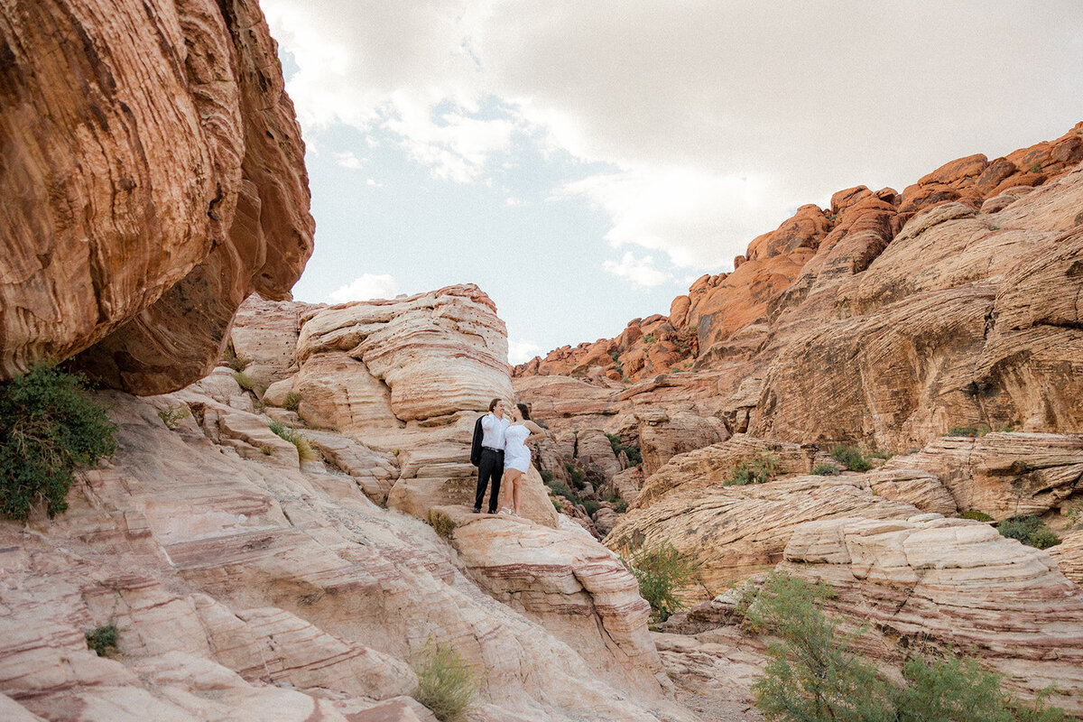 Landscape image of engaged couple on a rock at the Red Rock Canyon