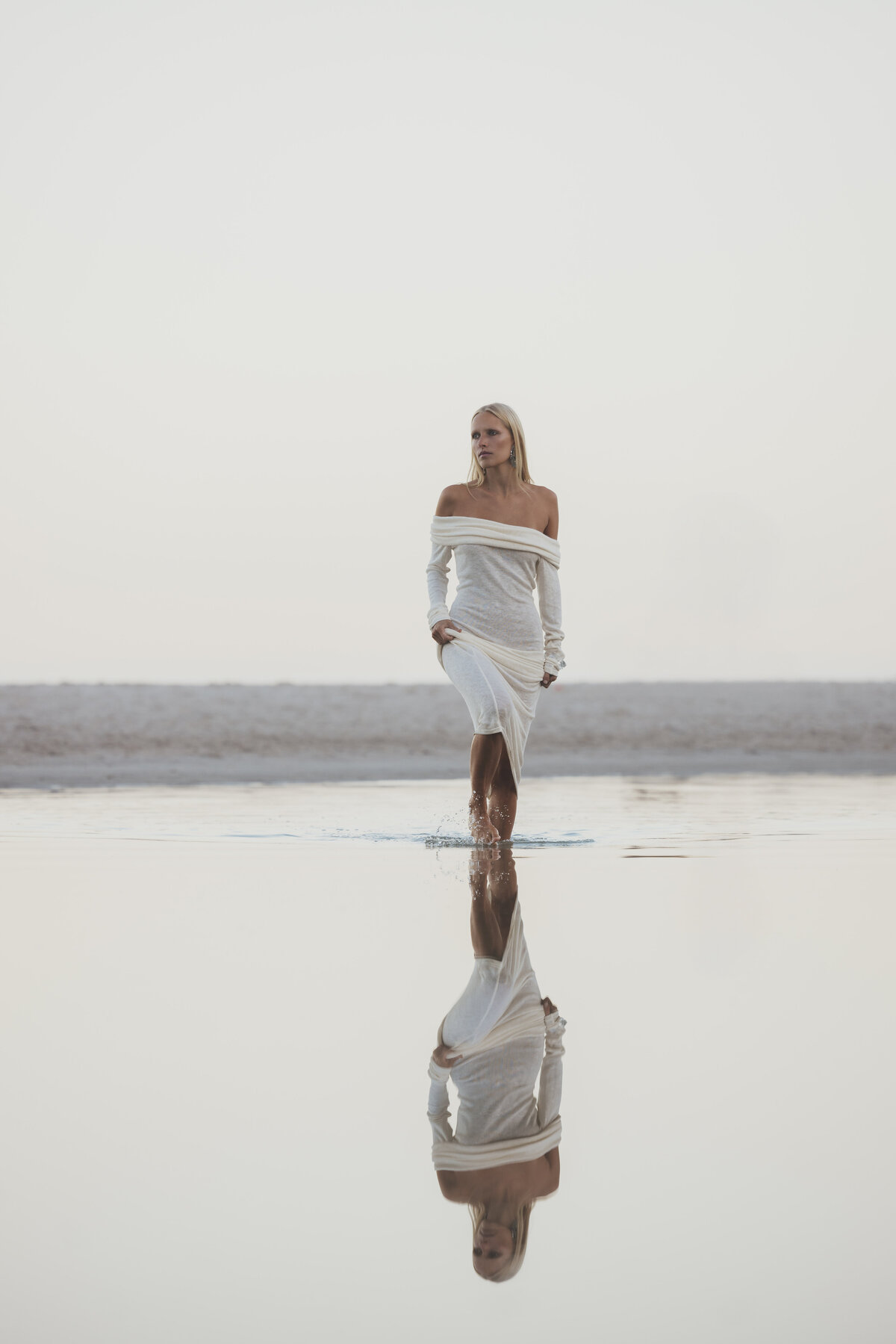 Model poseert op een rots aan het strand van Kaapstad tijdens golden hou
