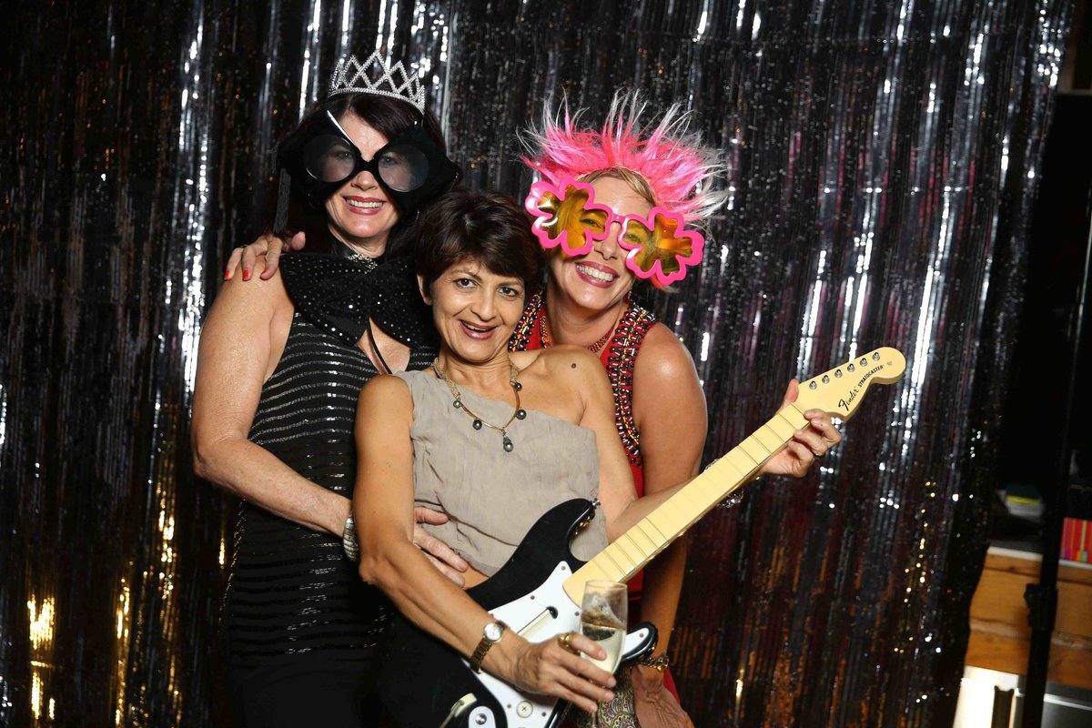 Three ladies use photobooth props: guitar, funky glasses, pink wig, and a crown. Photobooth by Ross Photography, Trinidad, W.I..