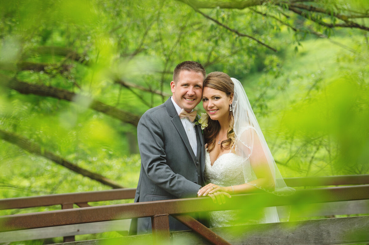 Bride and groom on bridge.