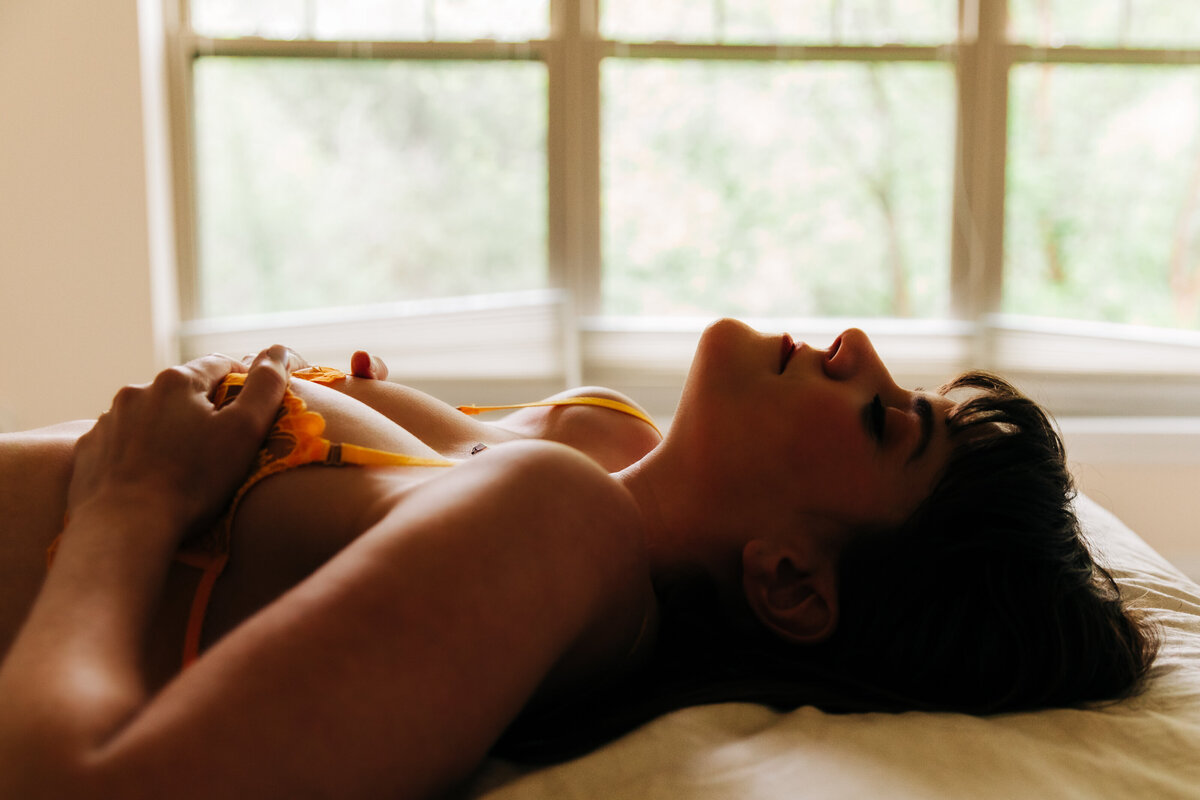 Boudoir photo woman on bed wearing yellow lingerie