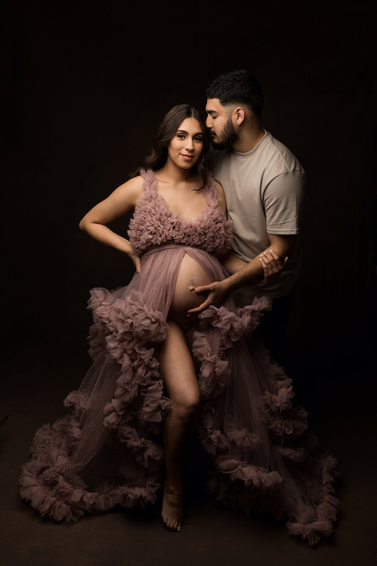 pregnant mother and father pose in studio with ruffle gown for phoenix maternity session