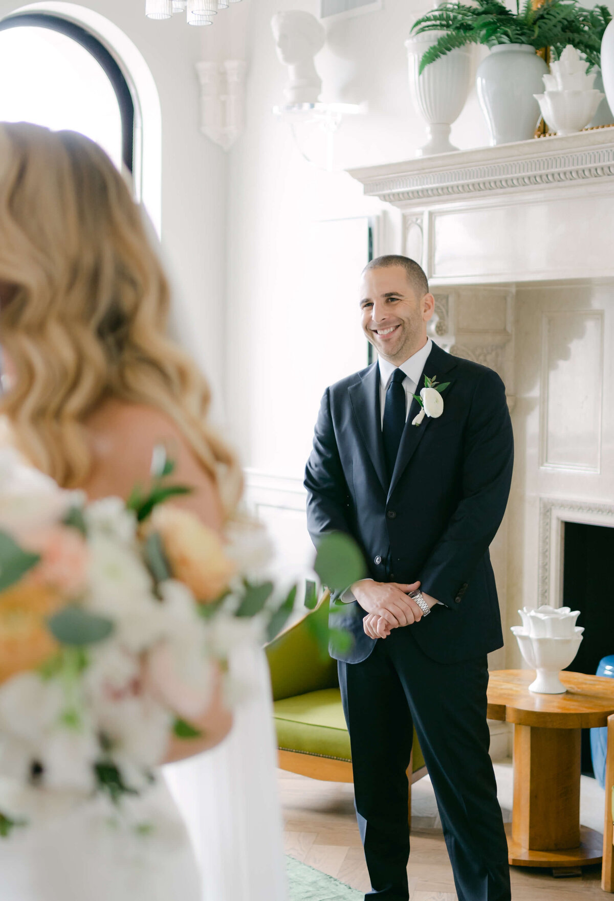 A groom smiles seeing his bride for the first time.