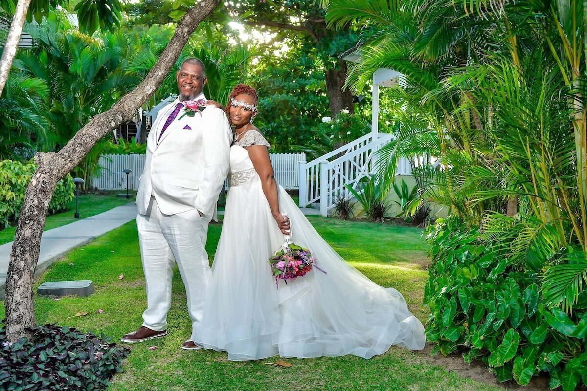 Bride and groom pose in front of palm trees in St. Lucia