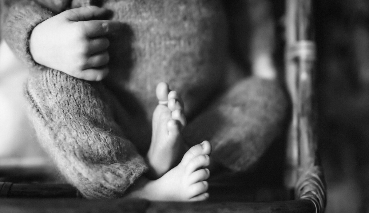 black and white photo of small newborn baby feet