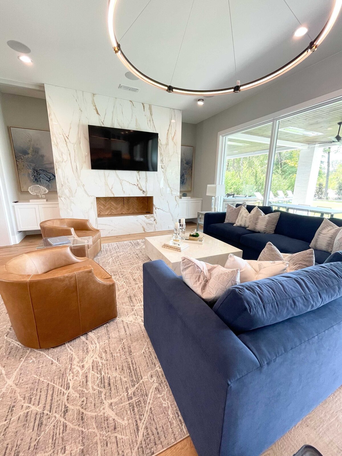 Residential interior design services for a living room project featuring a blue couch and a circular ceiling lamp, creating a unique and modern space.