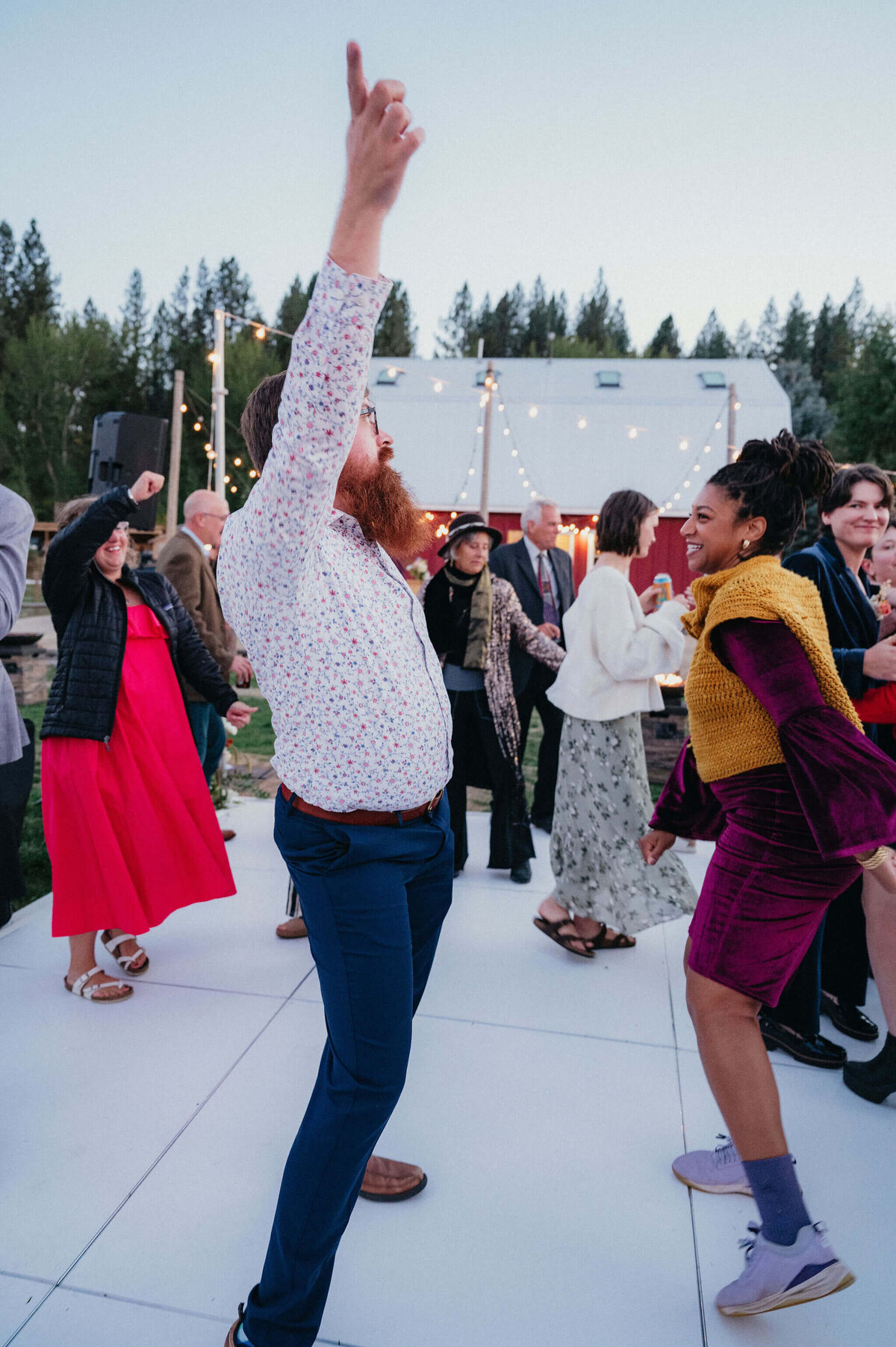 Wedding guests dancing on outdoor dance floor.