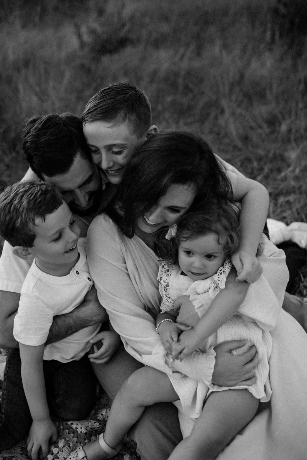 black and white image family hugging mother