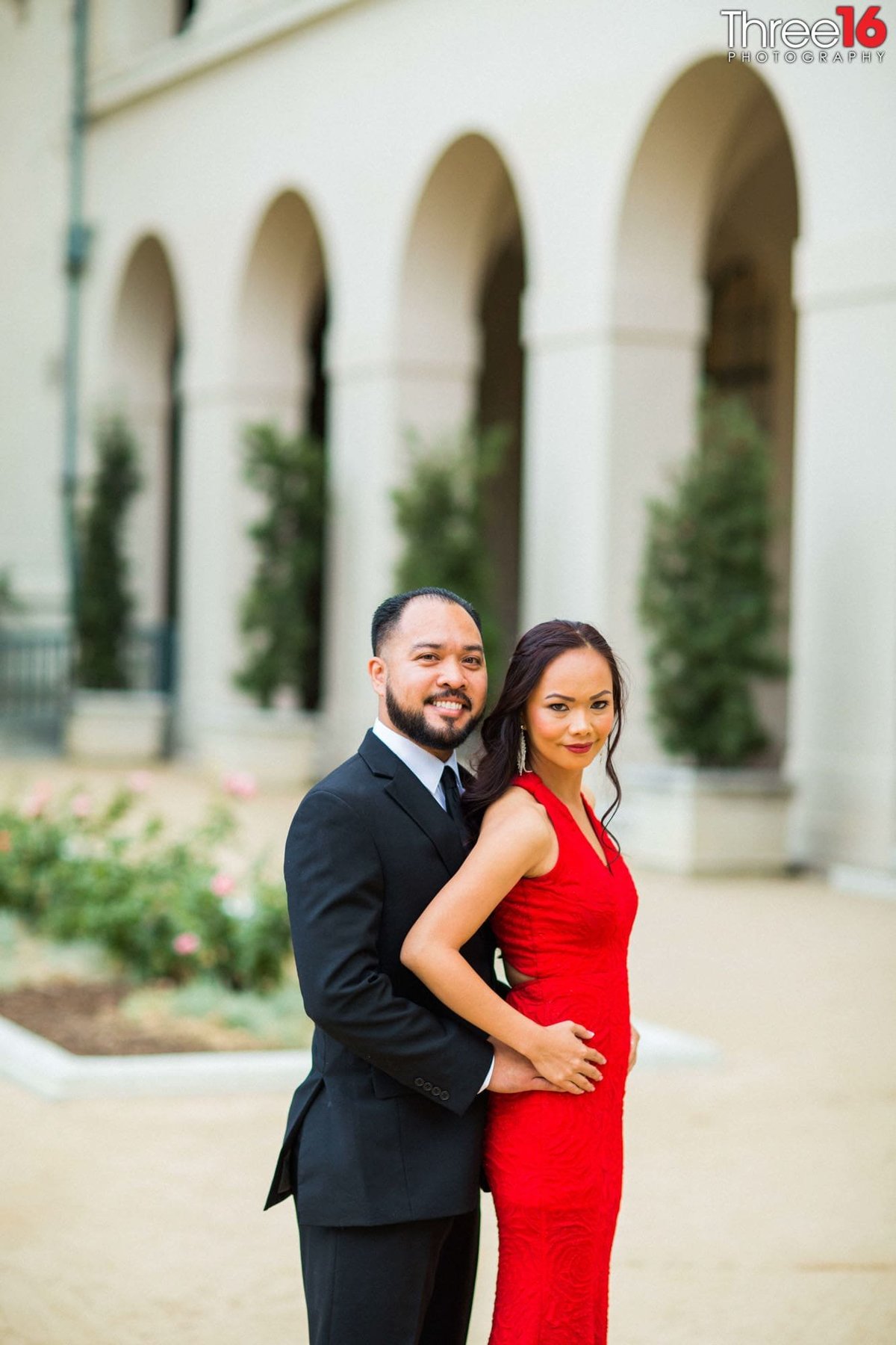 Groom to be holds his fiance's waist during photo session