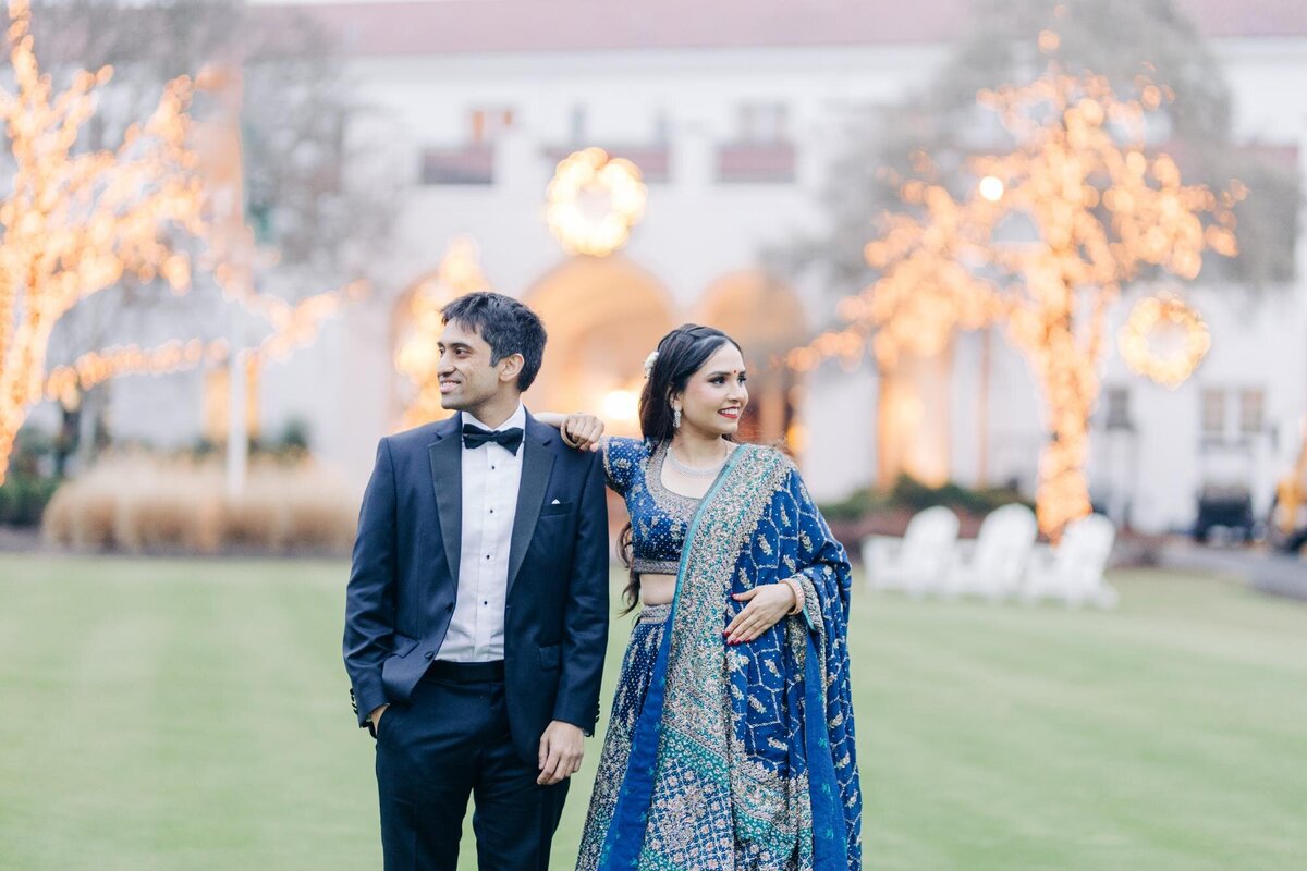 Indian bride and groom posing for a photo in traditional Indian wedding garments.