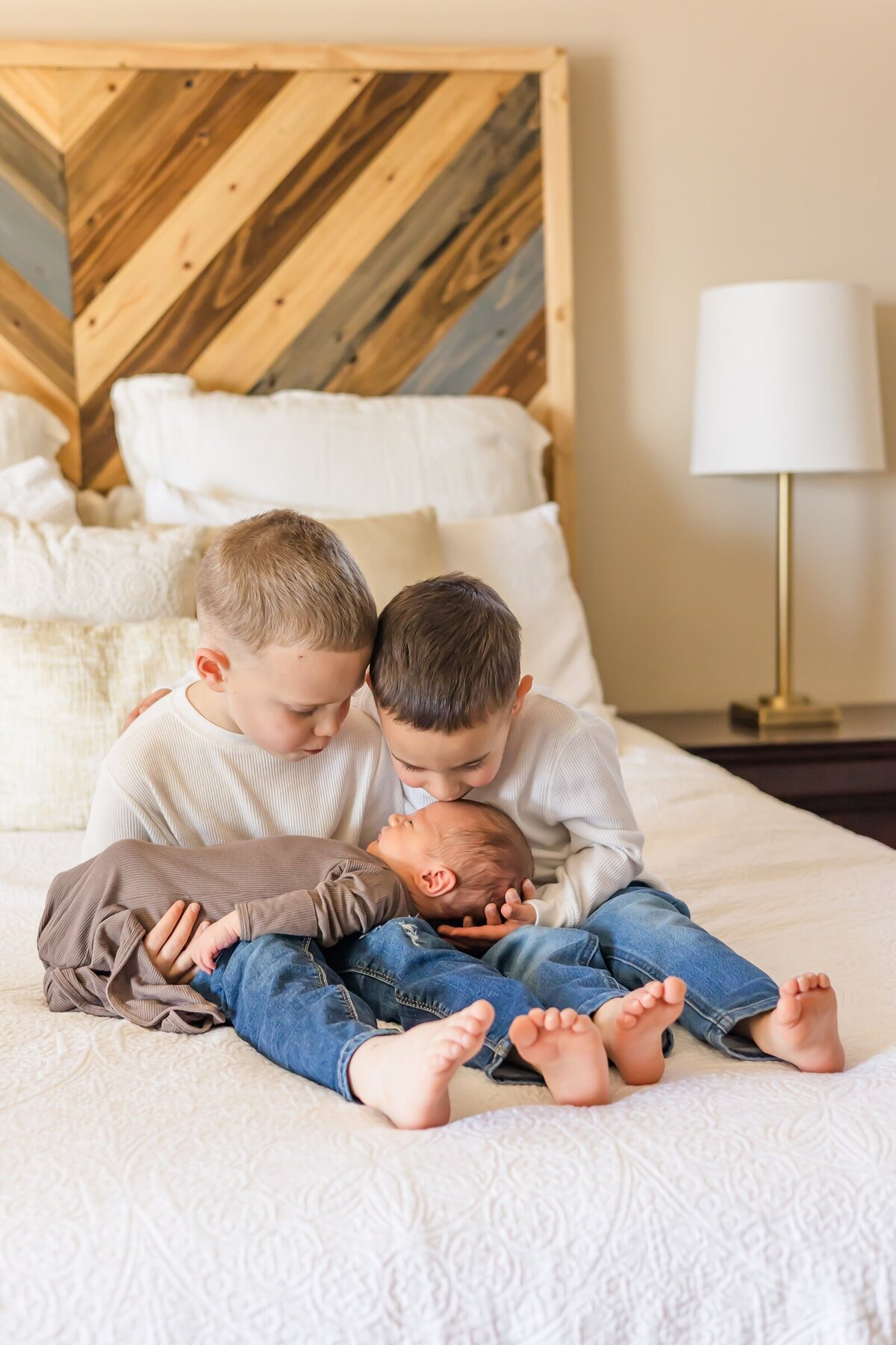 Big brothers kissing their baby brother at a lifestyle newborn session