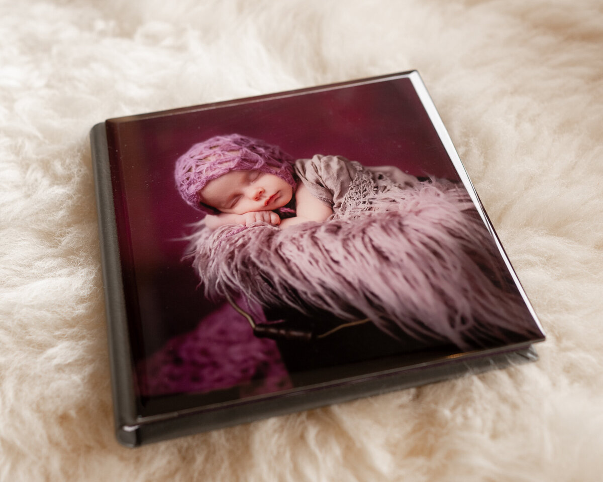 A closed fine art photo album sits on a fur blanket