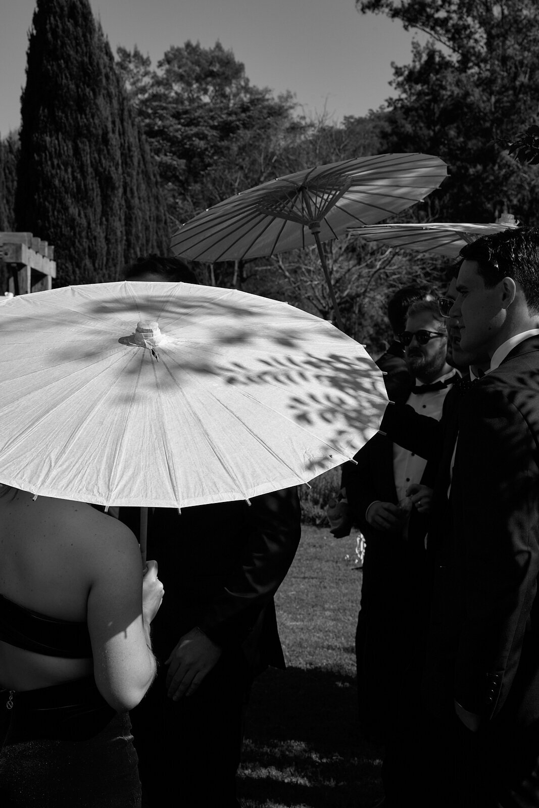 Tight view of a garden ceremony at Redleaf Wollombi, showing guests with their umbrellas.