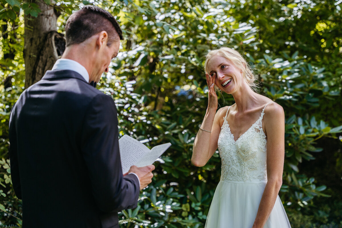 Bride laughing while listening to vows