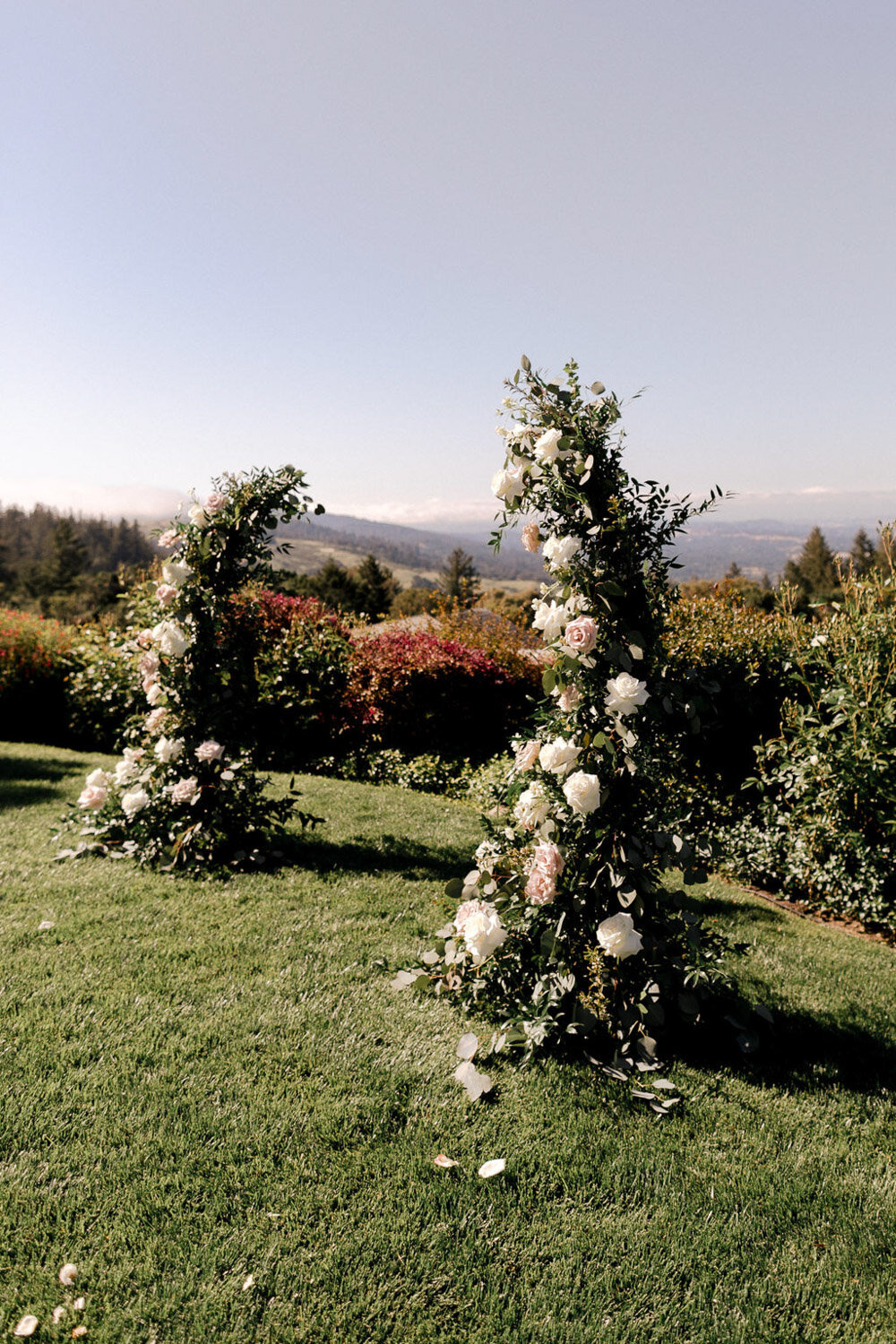 Romantic outdoor wedding ceremony with floral arch and scenic mountain view
