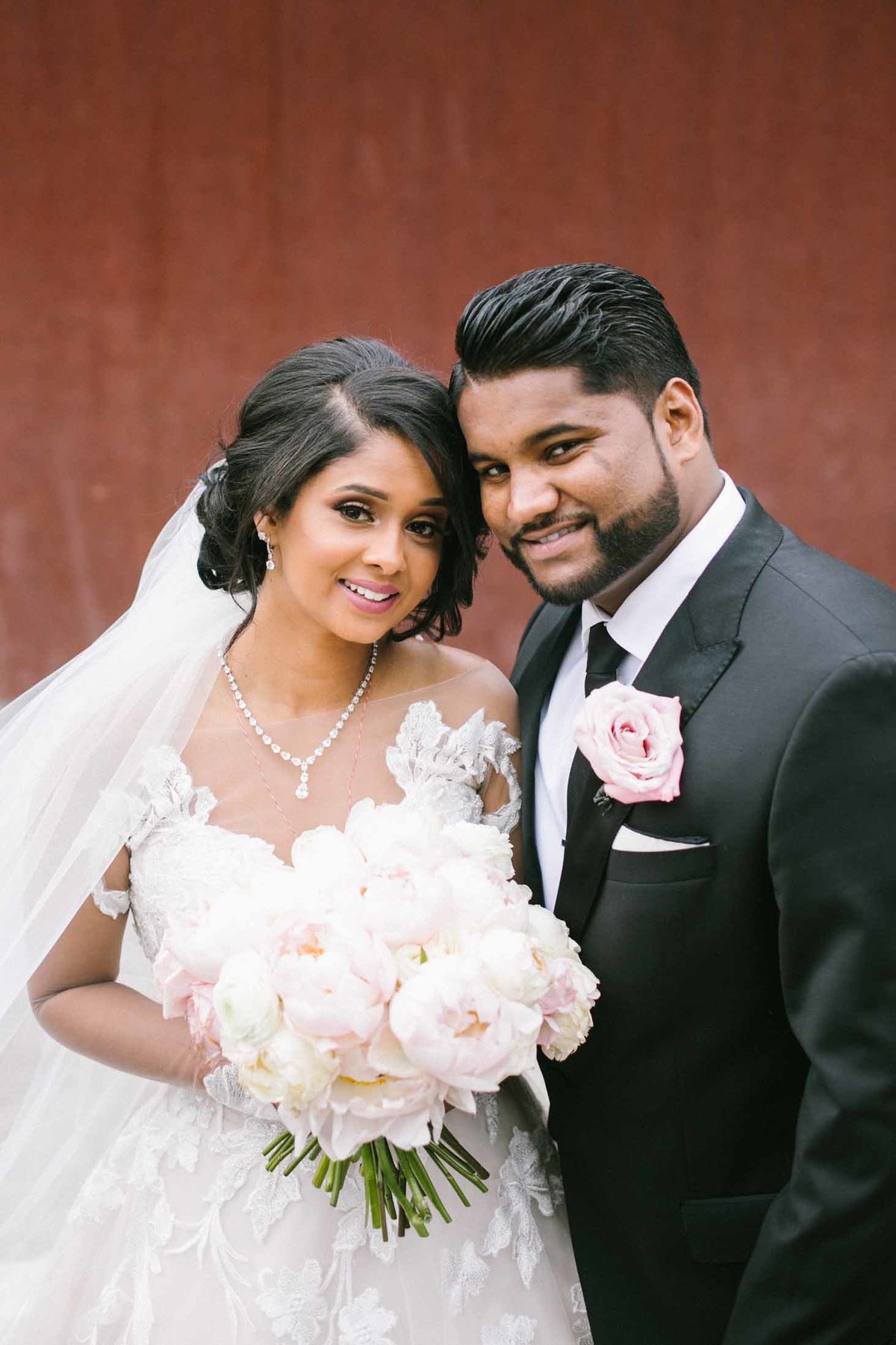 Indian bride and groom with blush peony bouquet