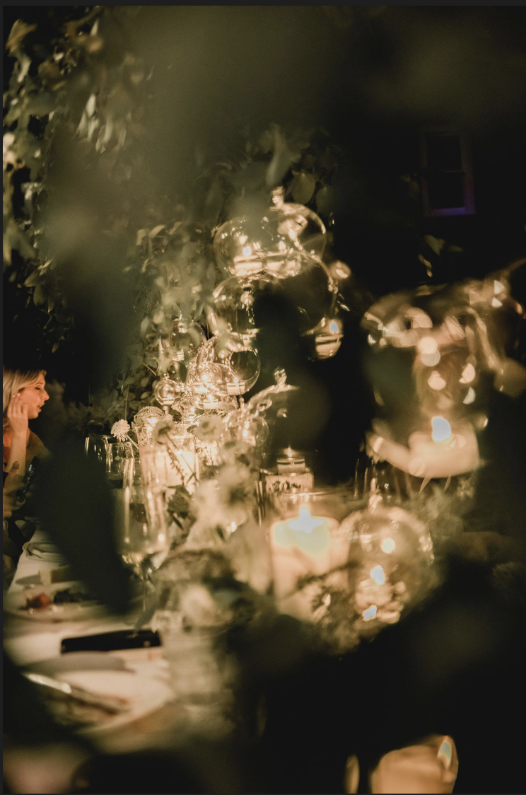 Romantic evening event under string lights at Hasbrouck House in the Hudson Valley, featuring glowing candles and intimate atmosphere.