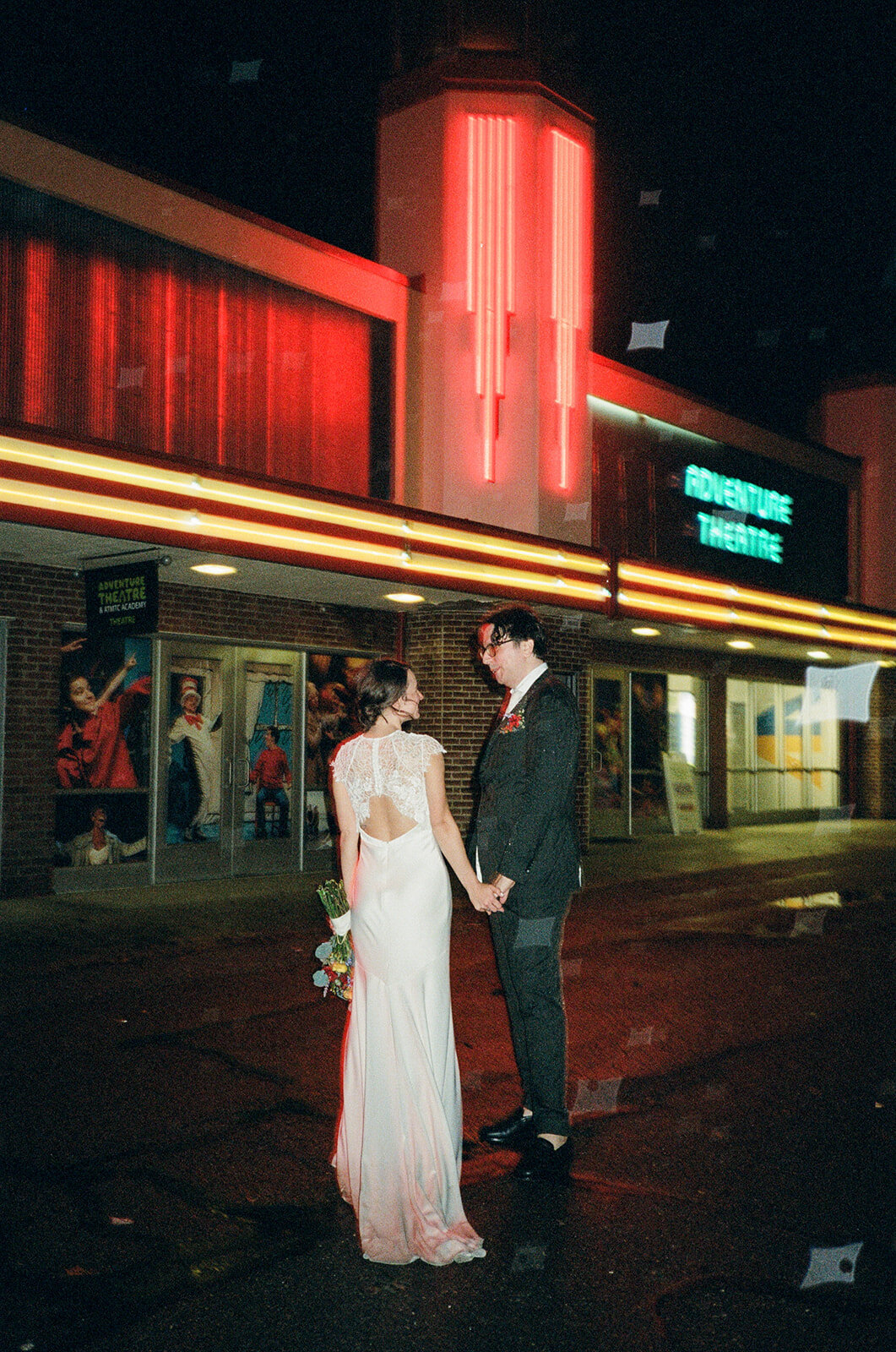 Washington DC wedding photographed on 35mm analog film in the pouring rain under neon lights