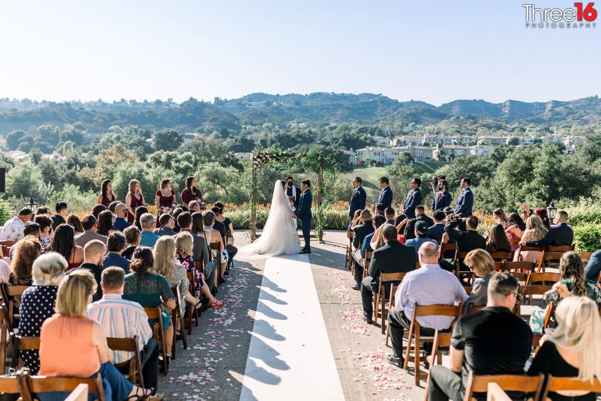 Bride and Groom face each other during the ceremony overlooking the Coto de Caza landscape