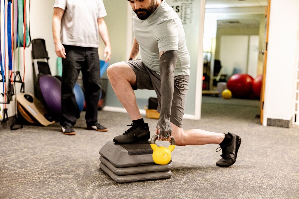 Person doing a kettlebell lunge for wellness physical therapy at Embody