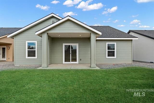 sage green house with glass patio door and grass in yard